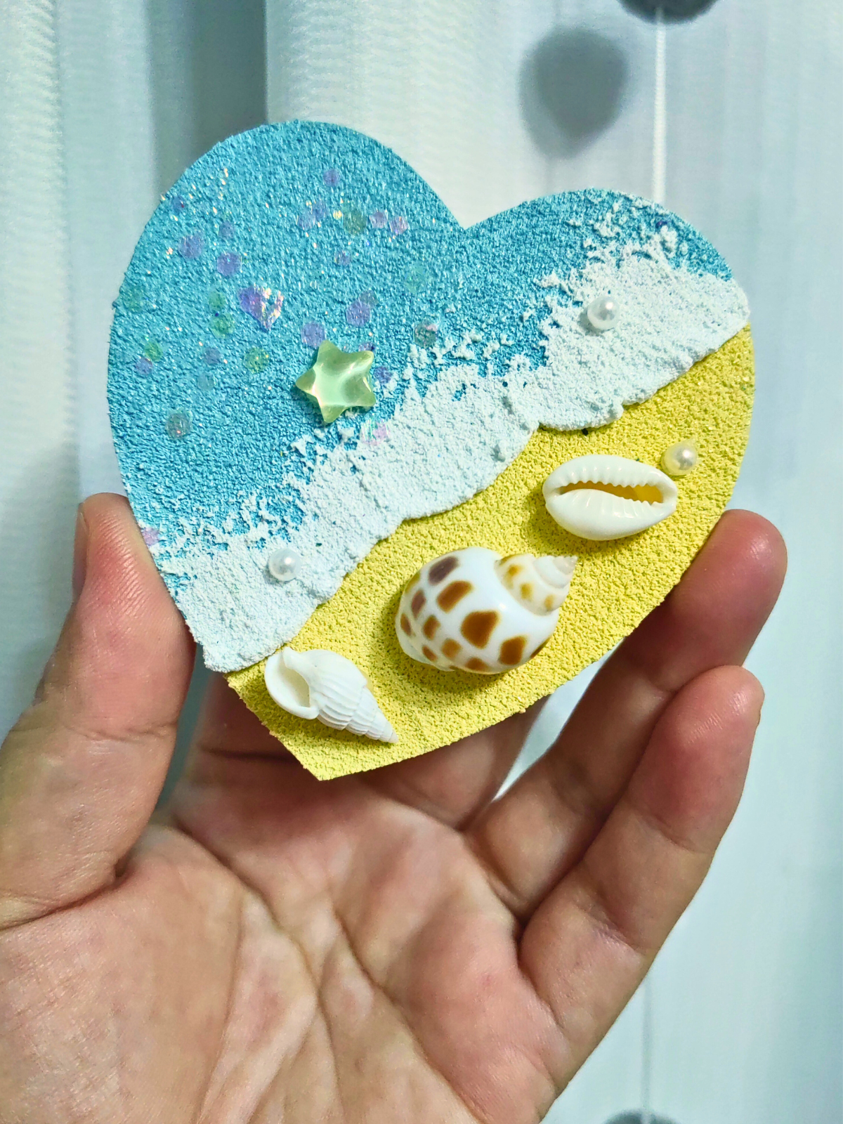 Heart-shaped ocean magnet with natural shells on wood
