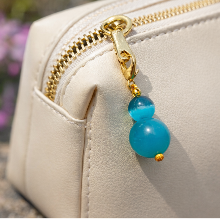 Minimal bead charm with gold-tone lobster clasp, close-up detail