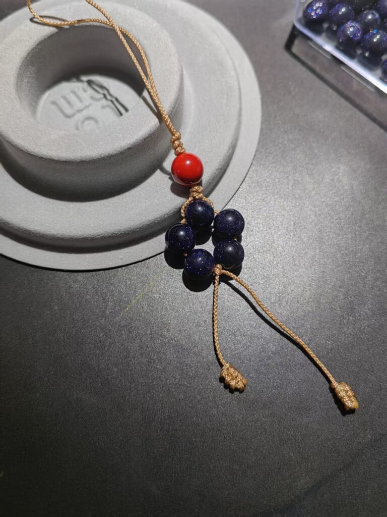 Hand-woven starry obsidian five-star charm with cinnabar bead and sand-gold cord by PICKLNN