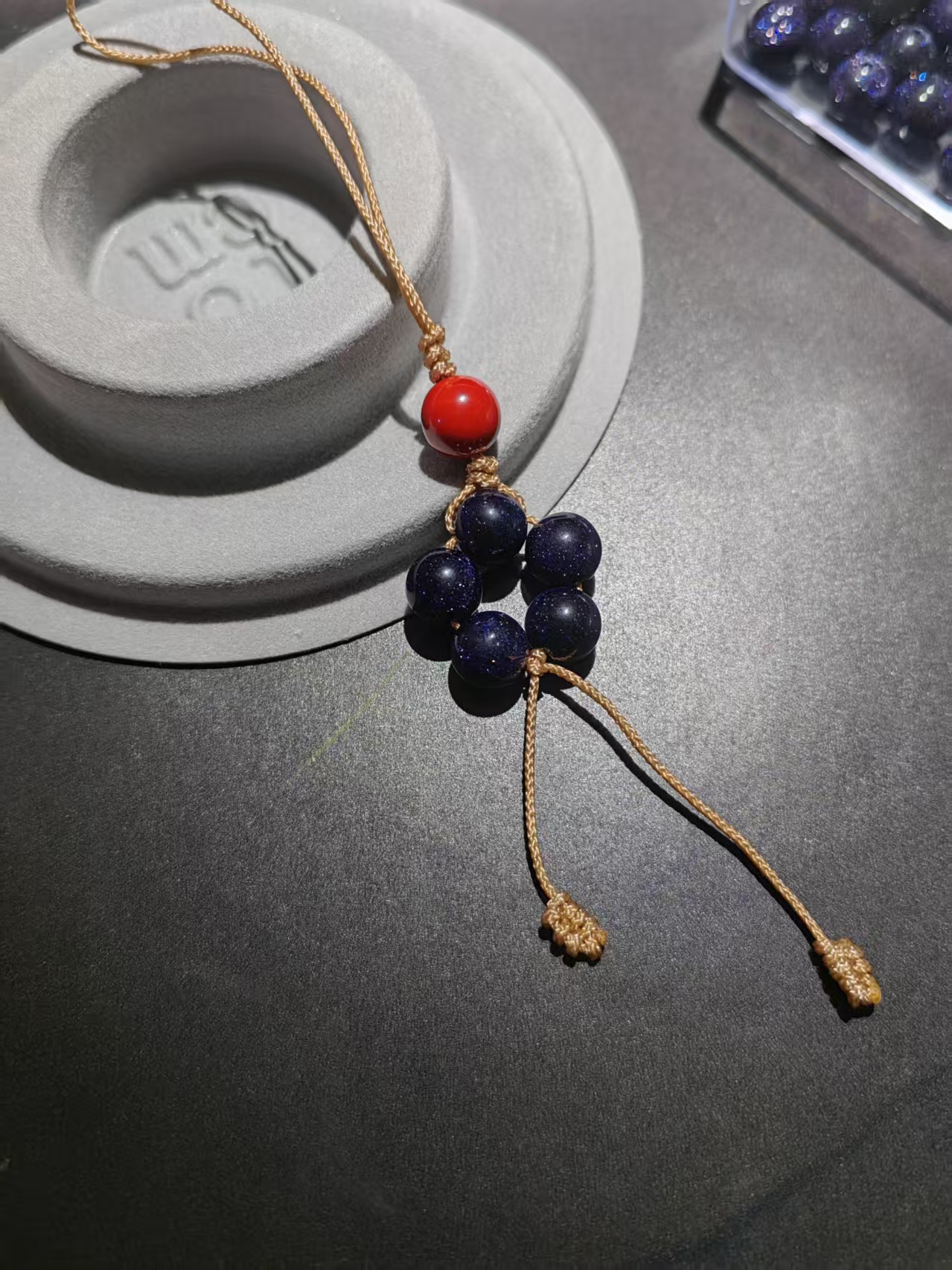 Hand-woven starry obsidian five-star charm with cinnabar bead and sand-gold cord by PICKLNN